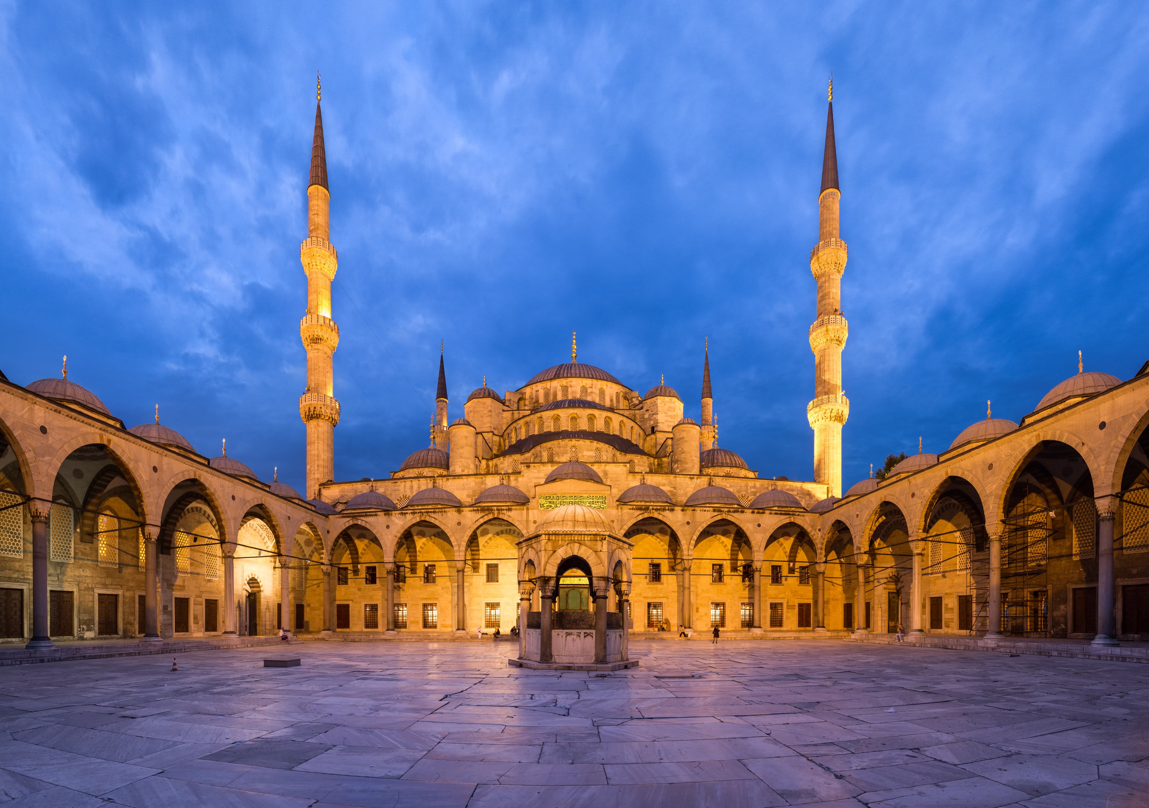 The Blue Mosque courtyard at dusk in Istanbul's historic Sultanahmet district.