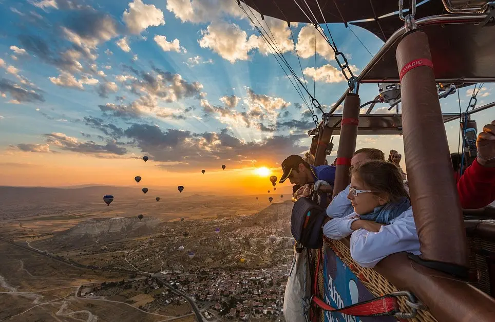 Dozens of balloons floating above Göreme valley at dawn