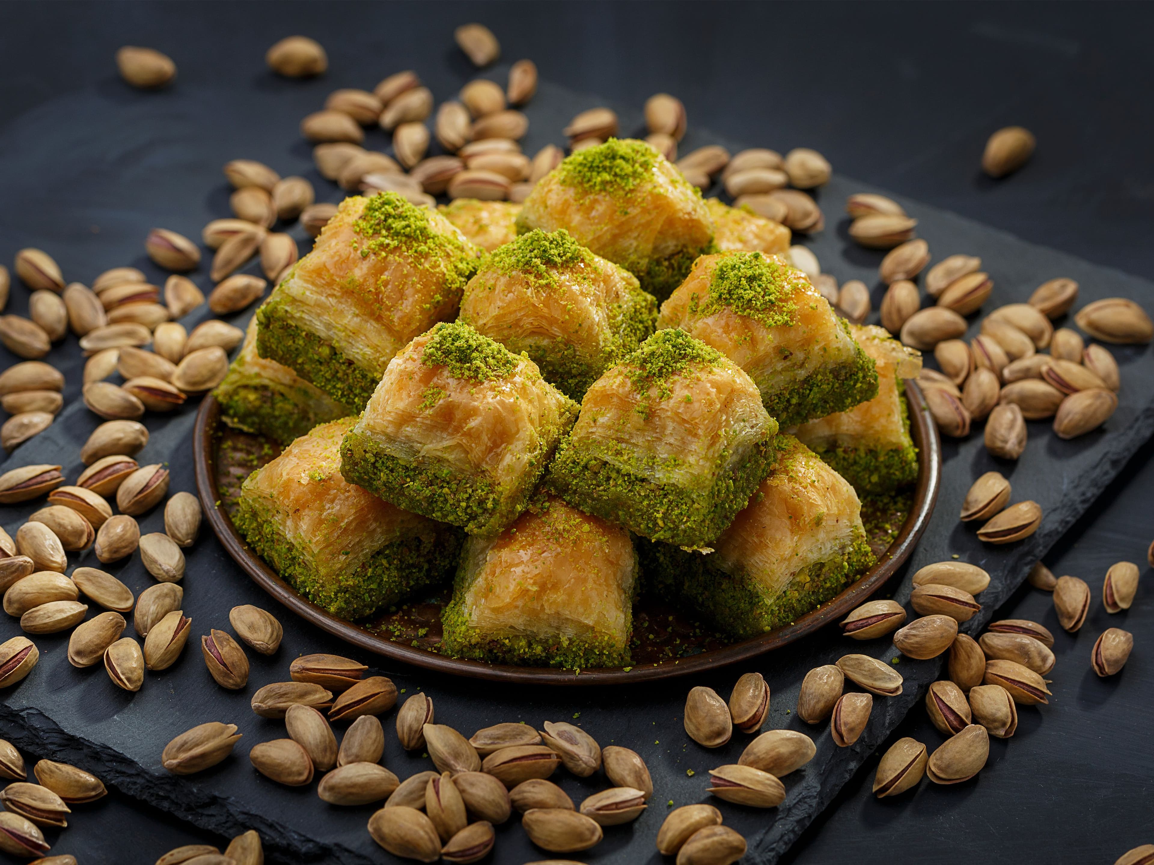 Authentic Gaziantep pistachio baklava surrounded by fresh green Antep pistachios